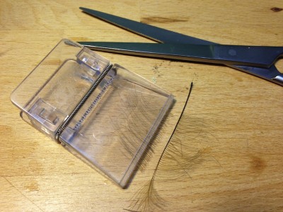 5.Bindeschritt:<br />Die vorbereitete CDC Feder wird nun in die Materialklemme eingespannt und knapp am Federkiel abgeschnitten. ACHTUNG Es wird nur eine Hechelseite verwendet und dazu auch nur die Bereiche der CDC-Feder wo die Grannen am ordentlichsten &amp; längsten sind!